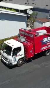 An aerial view of a Stars Junk Removal truck loaded with various items, ready for transport in San Jose, CA