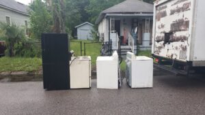 A refrigerator, stove, washer, and dryer lined up for appliance removal by Junk Fade Away, LLC in Jacksonville, FL.