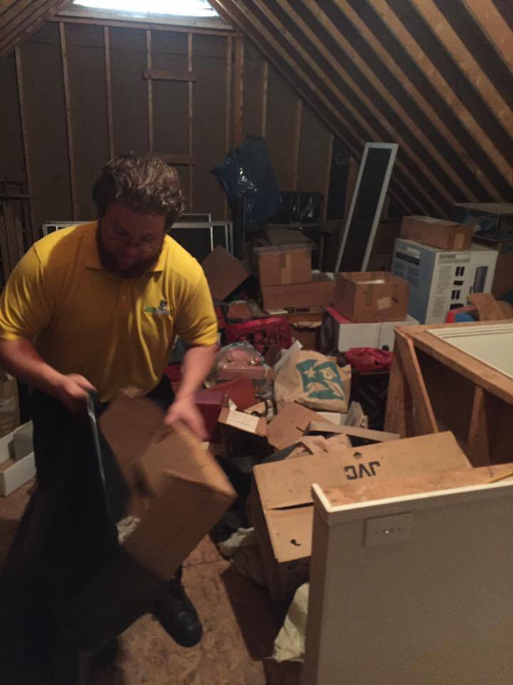 A Junk Doctors of Charlotte team member performing an attic cleanout, removing boxes and clutter in Charlotte, NC.