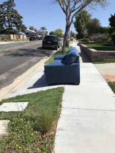 A large pile of cardboard, wood, and general debris in a backyard, ready for Jake's Junk Removal in San Diego, CA.