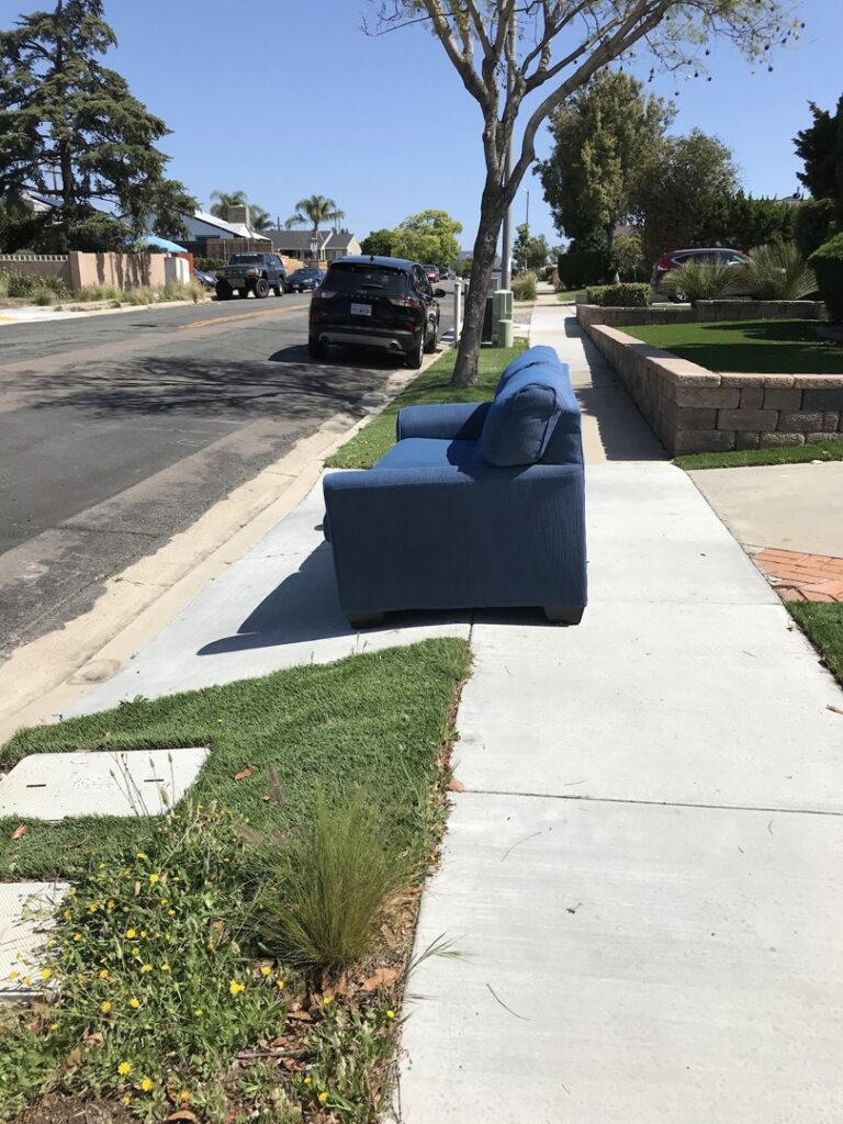 A large pile of cardboard, wood, and general debris in a backyard, ready for Jake's Junk Removal in San Diego, CA.