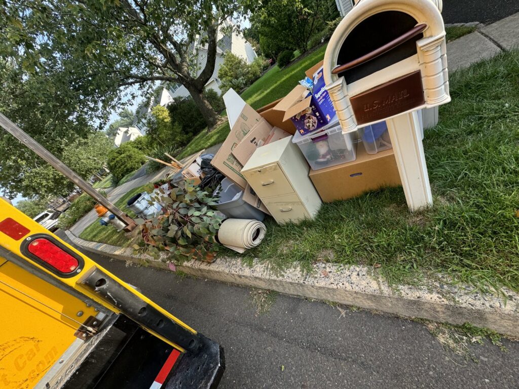 A large pile of assorted household junk and trash bags in a backyard, ready for removal by High Speed Junk Removal in Levittown, PA.
