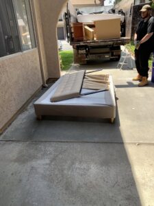 A bed frame and mattress components on a patio for Fred's Junk Removal in Chula Vista, CA.