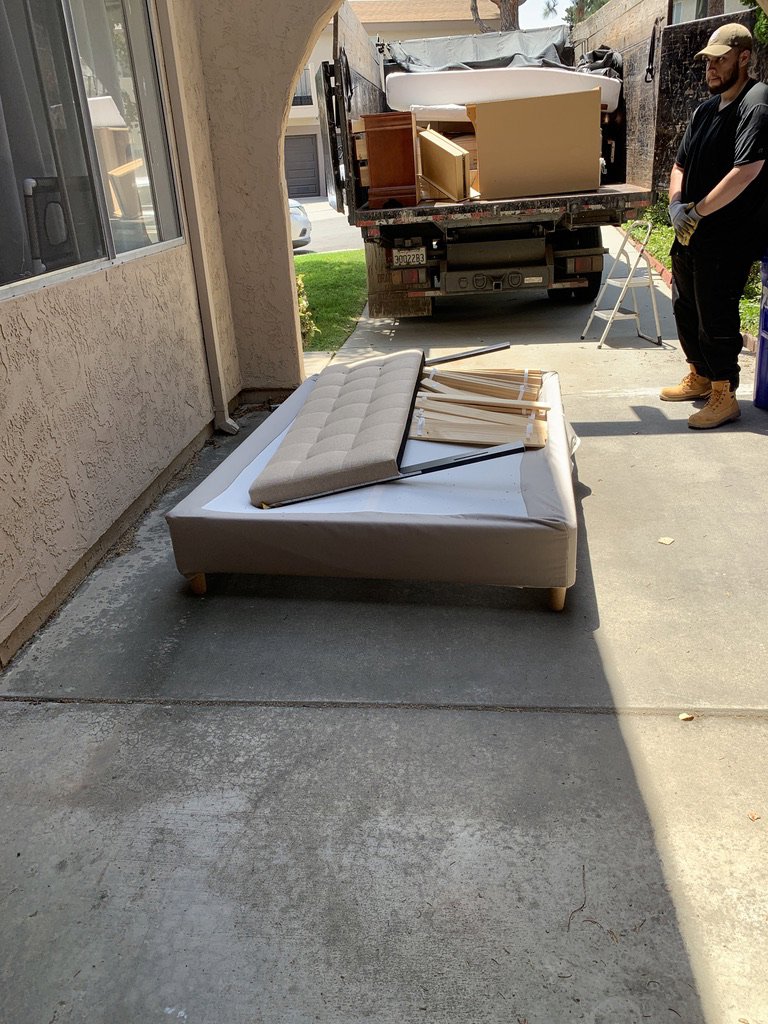 A bed frame and mattress components on a patio for Fred's Junk Removal in Chula Vista, CA.