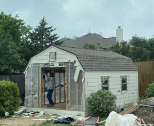A Bobcat skid-steer loader filling a junk removal trailer with debris for Big Ox Junk Removal in Leander, TX.