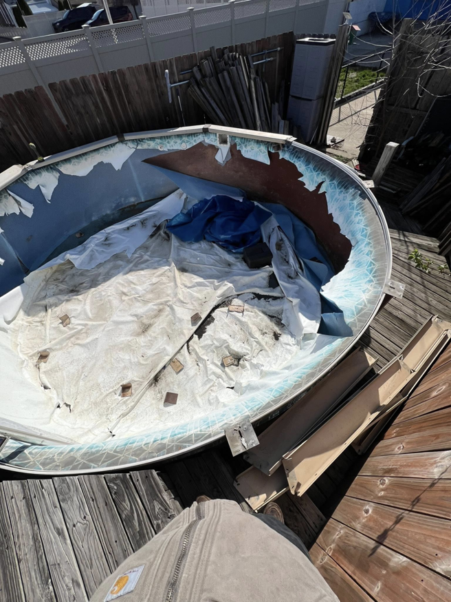 A close-up view of a broken above-ground pool liner and debris, ready for removal by Affordable Cleanouts LLC in Philadelphia, PA.