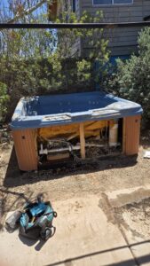 A broken hot tub with exposed components in a backyard, ready for removal by North Valley Junk Removal in Phoenix, AZ.
