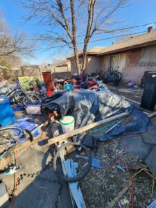 A heavily cluttered backyard filled with various items and debris, awaiting junk removal by All Needz Junk Removal & Hauling Service in Dallas, TX.