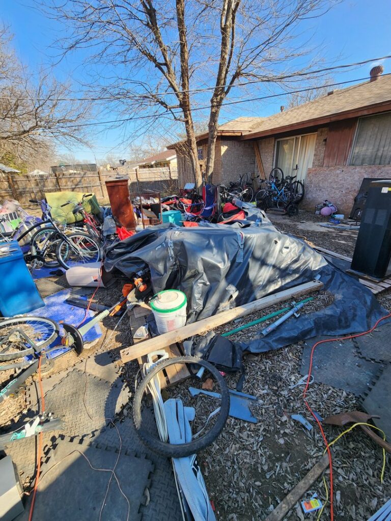 A heavily cluttered backyard filled with various items and debris, awaiting junk removal by All Needz Junk Removal & Hauling Service in Dallas, TX.