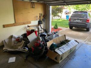 A cluttered garage filled with various items and debris, awaiting haul away service from Indy Trash Guy in Fortville, IN.