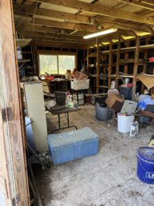 A cluttered garage interior showing items to be removed by Clear Your Junk - Pearland in Houston, TX.
