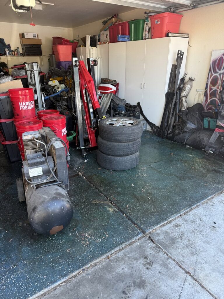 A cluttered garage filled with old tires, tools, and various items awaiting junk removal by Minutemen Junk Removal in Phoenix, AZ.