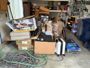 A cluttered garage filled with boxes and various items, awaiting junk removal service from Indy Trash Guy in Fortville, IN.