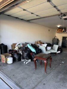 A cluttered garage filled with bags, boxes, and old furniture, ready for junk removal by North Valley Junk Removal in Phoenix, AZ.