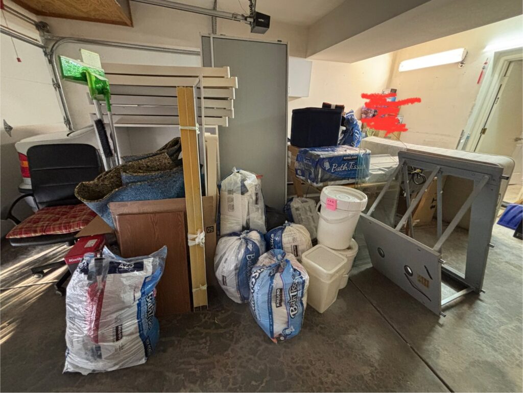 A cluttered garage filled with various junk items and bags, ready for a cleanout service by Johan's Junk Removal in San Diego, CA.