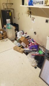 A cluttered laundry room with boxes, bags, and miscellaneous items ready for general junk removal by J & R Junk Removal in Phoenix, AZ.