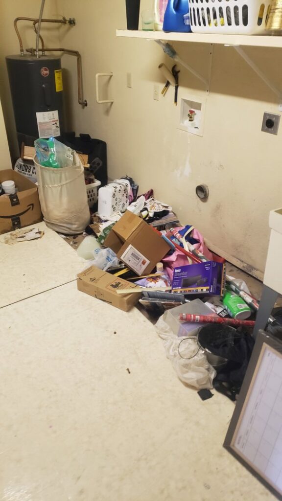 A cluttered laundry room with boxes, bags, and miscellaneous items ready for general junk removal by J & R Junk Removal in Phoenix, AZ.