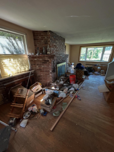 A cluttered living room with debris, boxes, and household items scattered on the floor, awaiting junk removal by Nolen's Junk Removal in Feasterville-trevose, PA.