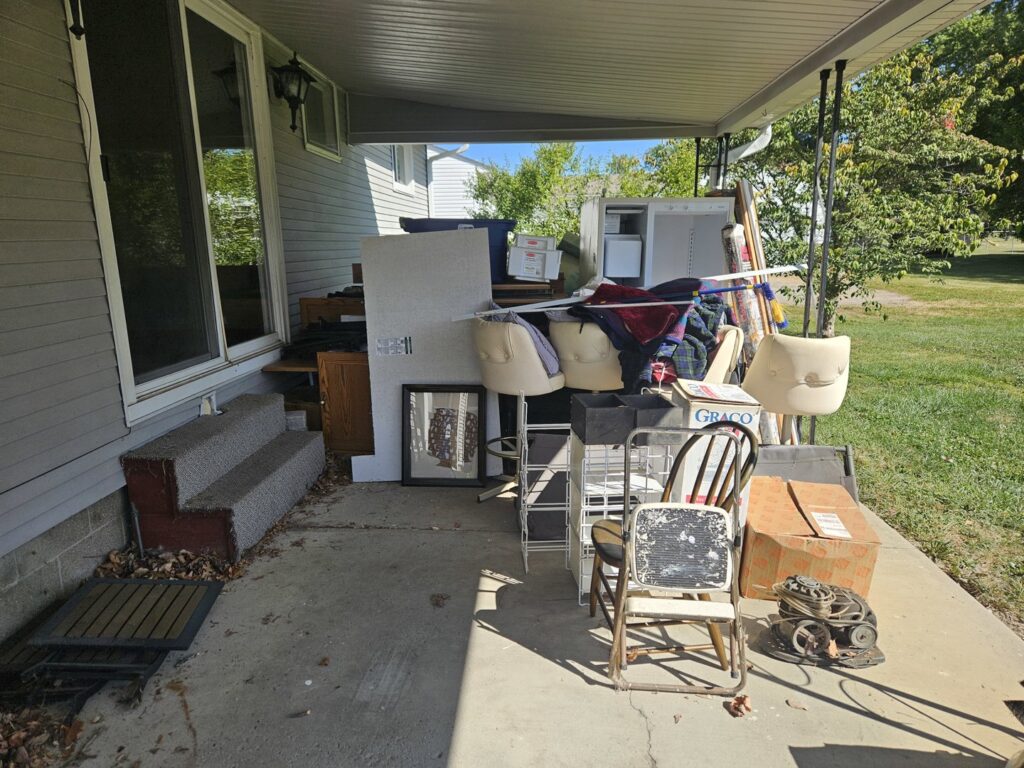 A cluttered residential porch filled with old furniture, boxes, and various items ready for junk removal by Purefoy's Professionals in Columbus, OH.