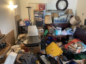 A cluttered room inside a home, showing a significant amount of junk and items requiring a cleanout service from JunkStart in San Antonio, TX.