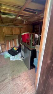 The cluttered interior of a shed, showing items to be removed by City to City Junk Removal in Fort Worth, TX.
