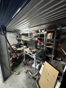 A cluttered storage unit filled with various items and debris, ready for cleanout by Crisan Junk Removal in San Diego, CA.