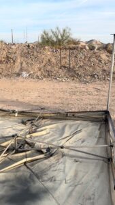 A collapsed tent and a large pile of debris in a dusty area, ready for junk removal by North Valley Junk Removal in Phoenix, AZ.
