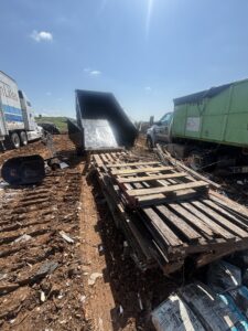 A large pile of wooden pallets and debris at a commercial site for junk removal by Big John's Demolition & Junk Removal in Charlotte, NC
