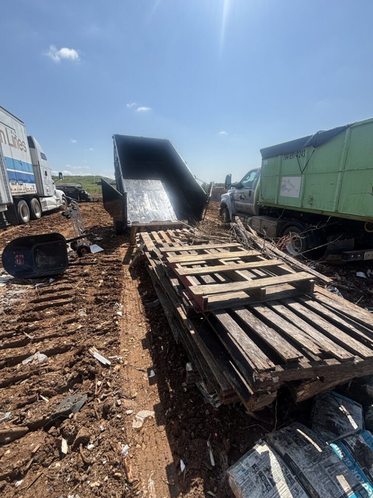 A large pile of wooden pallets and debris at a commercial site for junk removal by Big John's Demolition & Junk Removal in Charlotte, NC