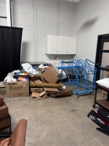 A room with cardboard boxes, packaging, and blue carts ready for commercial junk removal by Big John's Demolition & Junk Removal in Charlotte, NC