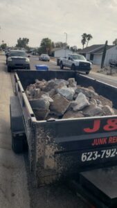 A J & R Junk Removal branded trailer filled with concrete and rock debris, ready for hauling in Phoenix, AZ.