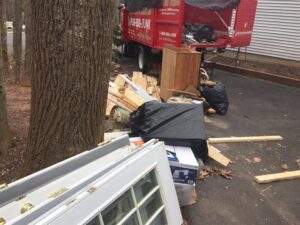 A pile of construction debris, including old doors and wood, ready for Junk King removal next to a truck in Austin, TX