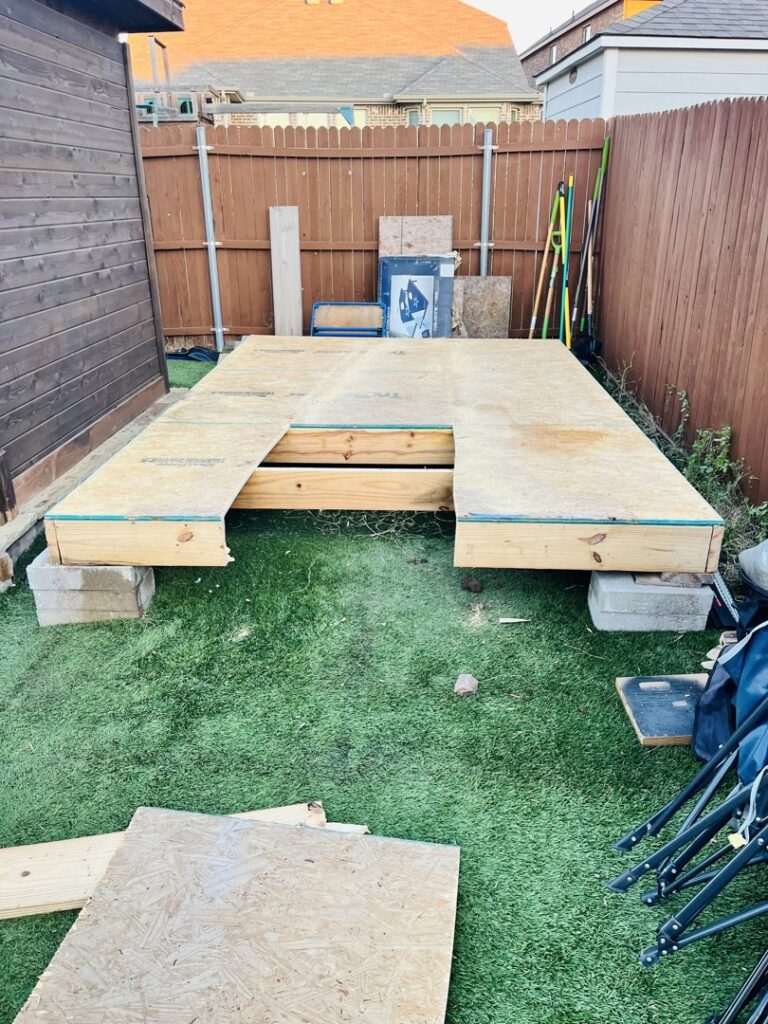 Construction debris and a wooden platform in a backyard, ready for removal by Hud's Haul Away Junk Removal & Demolition in Fort Worth, TX.