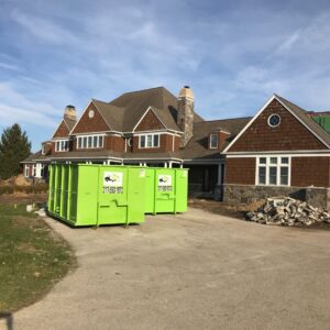 Two Bin There Dump That green dumpsters on a construction site with debris, providing junk removal in Indianapolis, IN.
