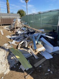 A large pile of construction debris, including wood and cardboard, ready for Crisan Junk Removal in San Diego, CA.