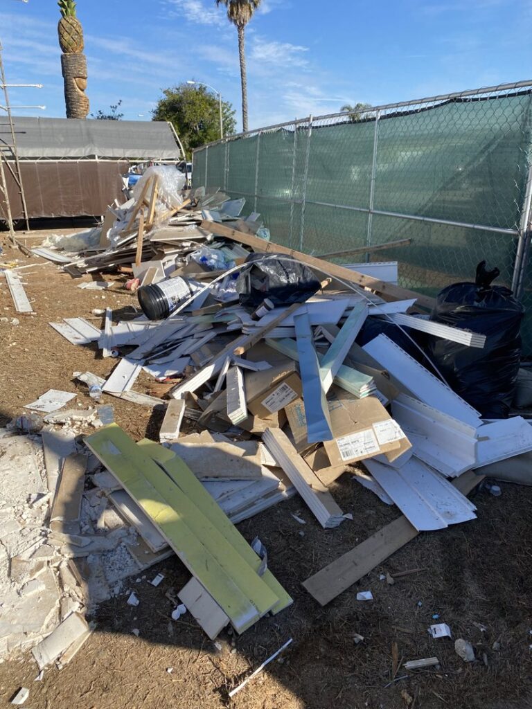 A large pile of construction debris, including wood and cardboard, ready for Crisan Junk Removal in San Diego, CA.