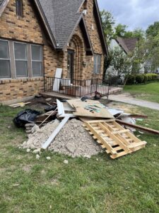 A large pile of construction debris, including wood and concrete, outside a house, handled by NTX Haul Away Junk Removal in Fort Worth, TX.