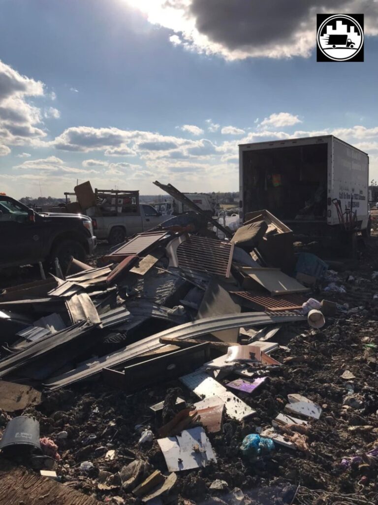 A large pile of construction debris at a junk removal site with a We Haul It Cleaning Service LLC truck in Canal Winchester, OH.