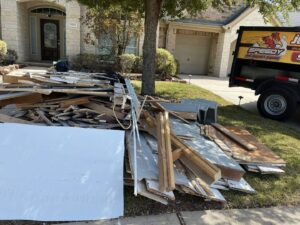 A large pile of construction debris on a lawn, ready for pickup by Speedy Junk Removal & recycling in Houston, TX.