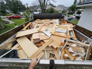 A junk removal truck bed being loaded with construction debris and wood scraps by The Mess Haul in Jacksonville, FL.