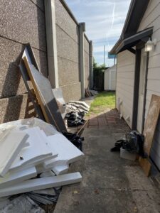Construction debris, insulation, and trash bags piled in an outdoor area for general junk removal by Get Junk Help in Houston, TX.