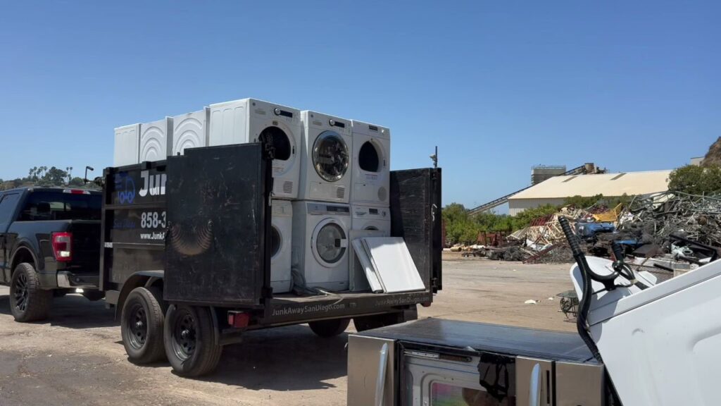A Junk Away - San Diego trailer positioned next to a large pile of insulation and ductwork for construction waste removal in San Diego, CA.
