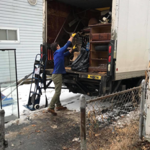 A crew member loading various junk items into a removal truck for Junk Removal and More LLC in Columbus, OH.