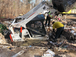 A Junk Doctors of Charlotte crew using a Bobcat skid-steer loader to clear debris from a site in Charlotte, NC.