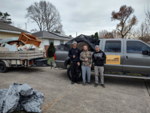 Load & Go Hauling Junk Removal crew with a truck and trailer full of removed junk in a residential driveway in Grove City, OH.