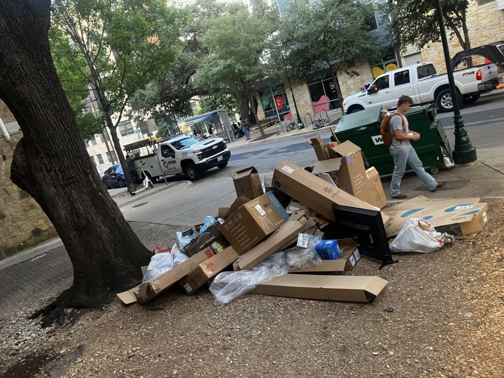 A curbside pile of cardboard boxes and trash bags awaiting pickup by Junkie 4 Jesus Junk Removal in Austin, TX