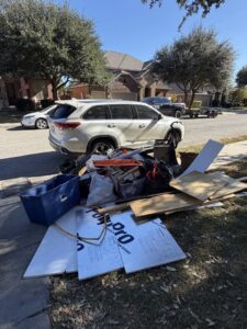 A large pile of curbside junk, including insulation, boxes, and bags, awaiting pickup by Faithful Hands Junk Removal in San Antonio, TX.