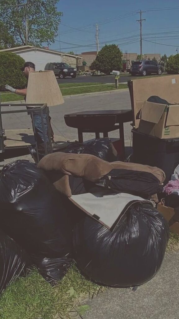 A large pile of household junk and black trash bags placed curbside for removal by Master Junkers in Powell, OH.