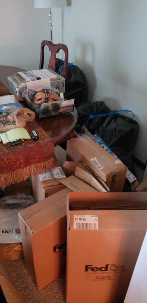 A pile of debris, old tires, and a green bin next to a removal truck for Junk Fade Away, LLC in Jacksonville, FL.