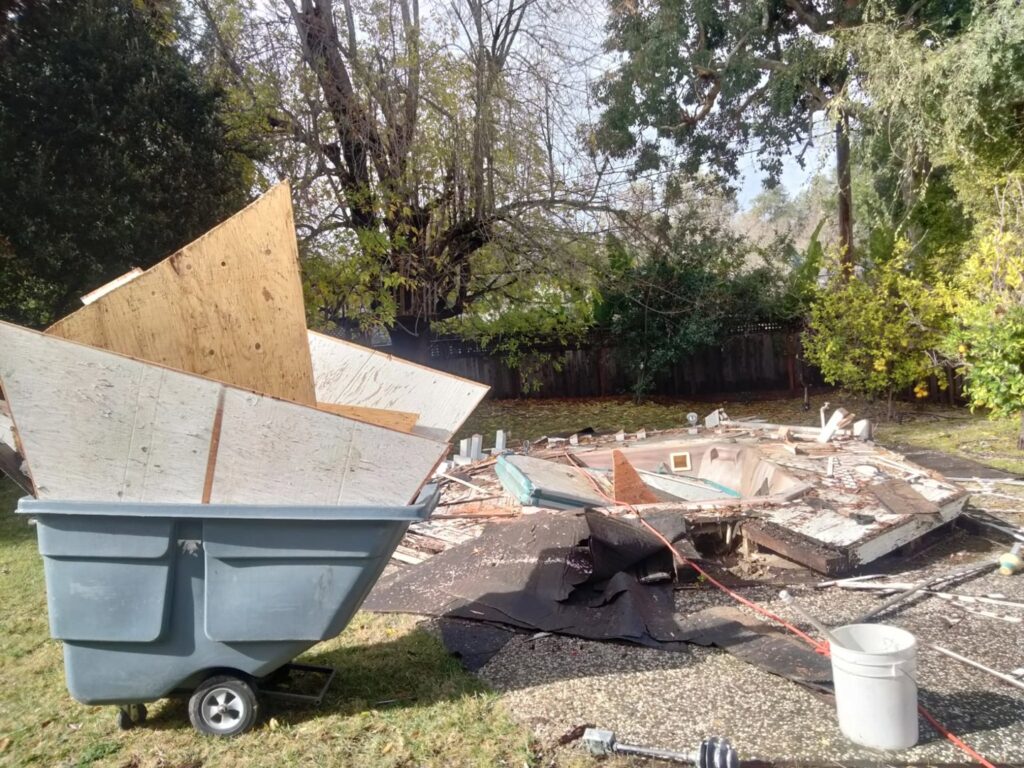 A large pile of demolition debris in a backyard, ready for removal by Strong Hands Hauling & Dumpster Rental in San Jose, CA